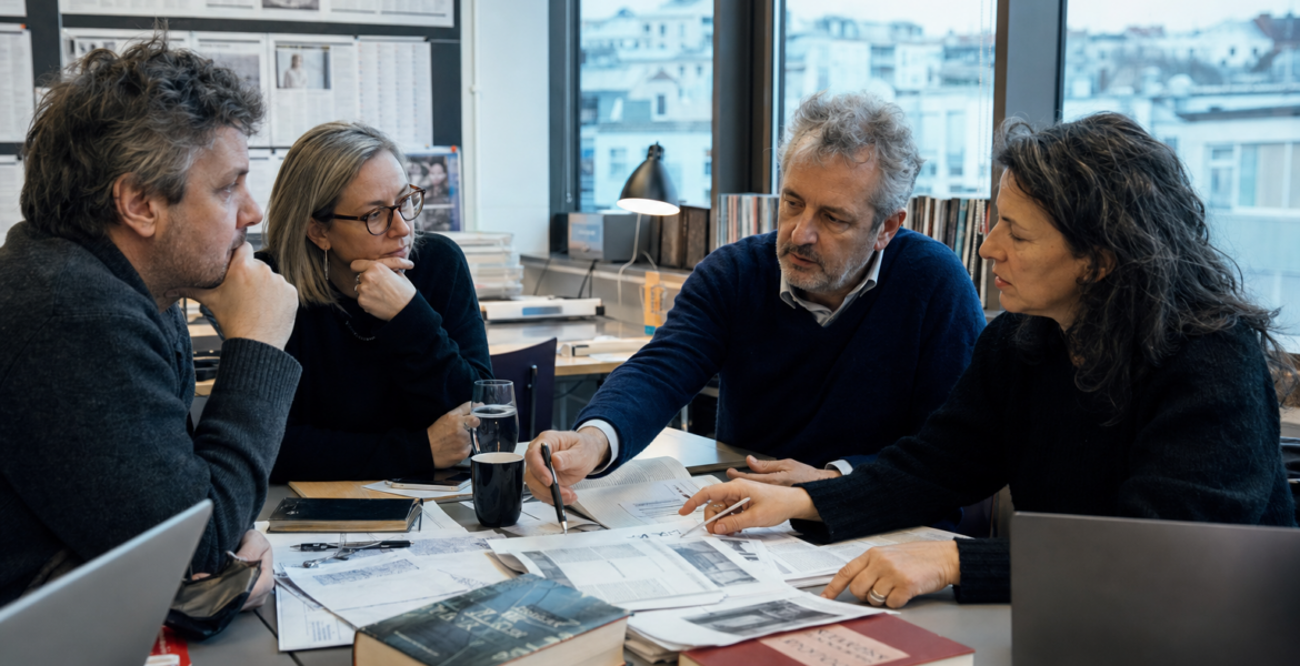 Editors and translators work around a table in a European newsroom.