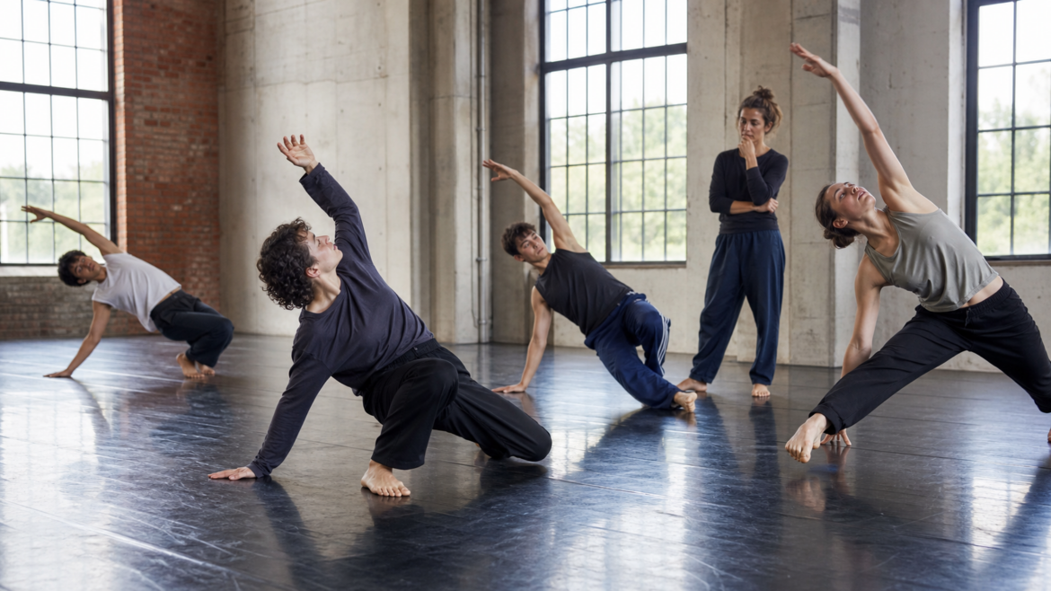 Contemporary dancers rehearsing in a restored industrial hall